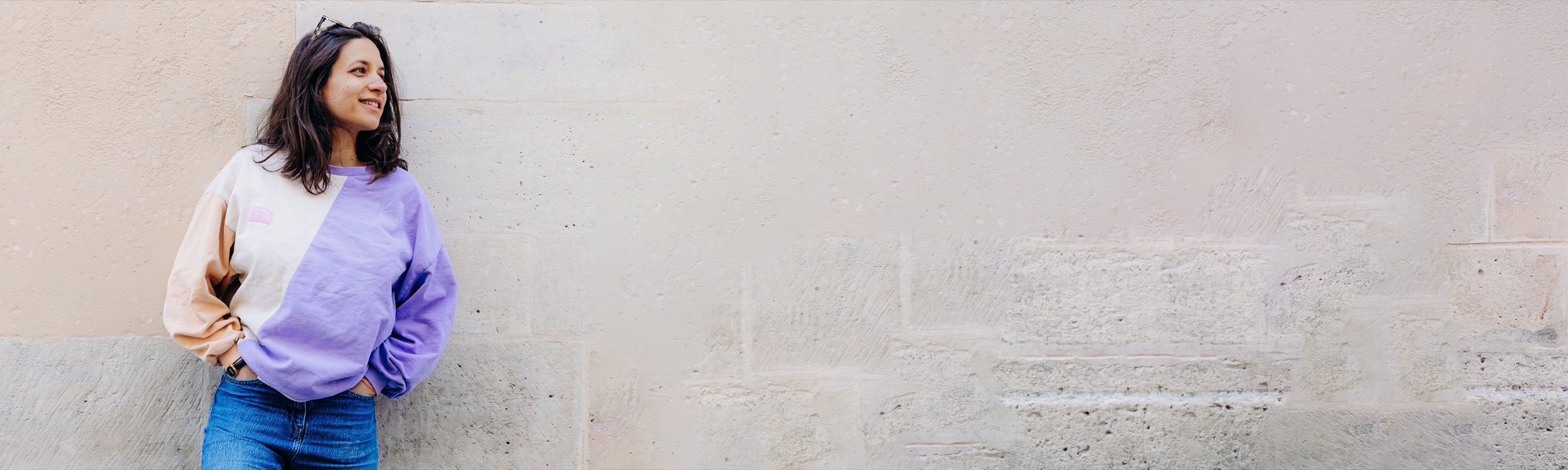 Sarah Yogi devant un mur de pierre clair