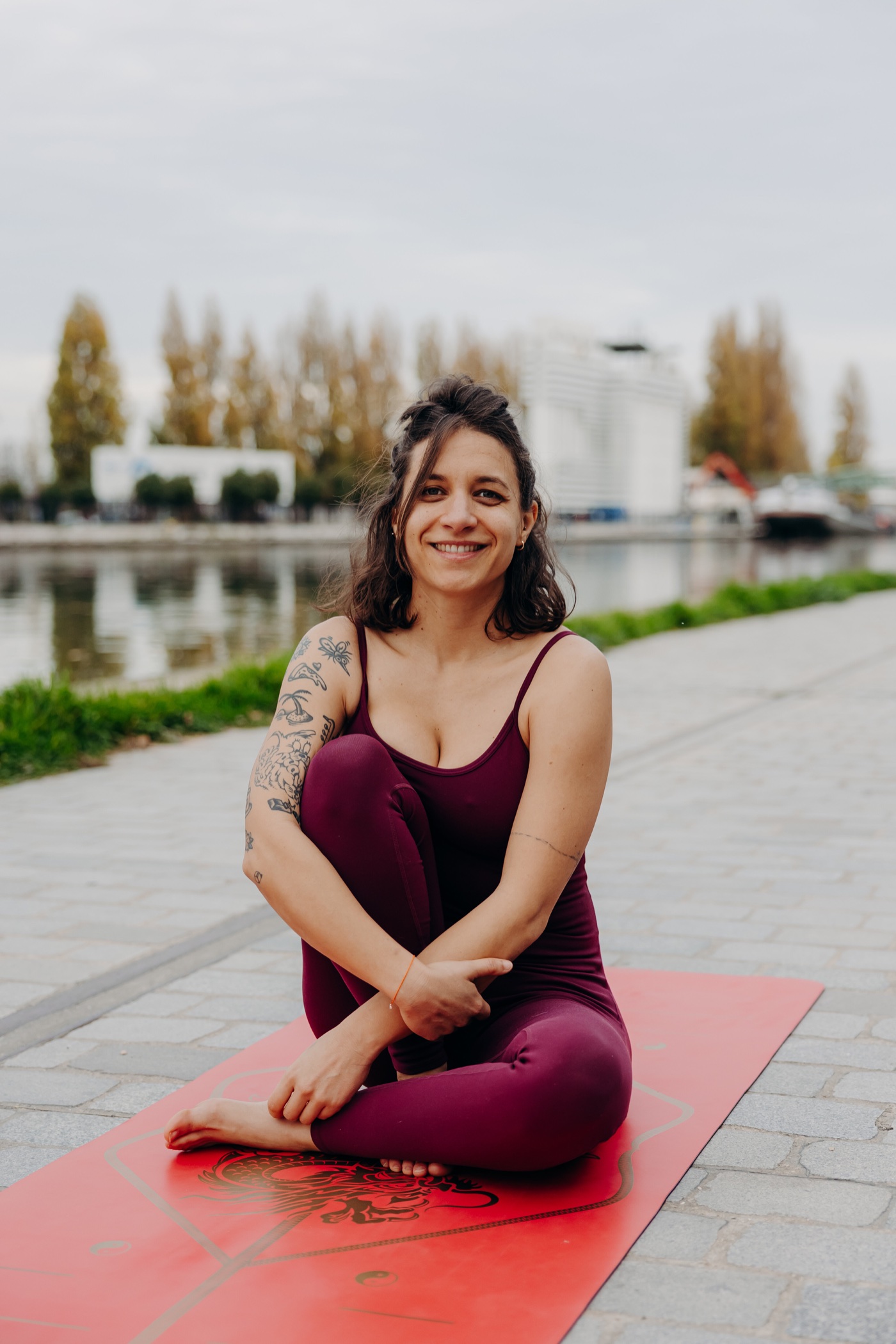 Sarah Yogi assise sur son tapis de yoga au bord du canal